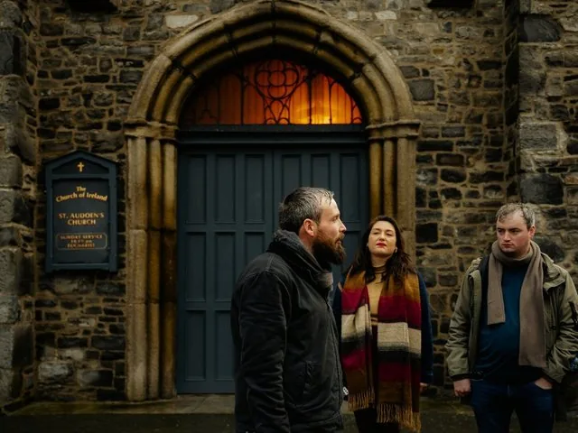 Tour group standing outside St. Audoen's Church listening to a guide