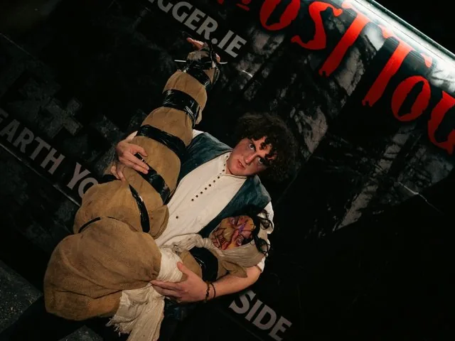 Actor carrying a wrapped dummy outside the Gravedigger Ghost Tour