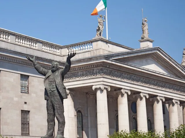Statue with raised arms in front of the General Post Office