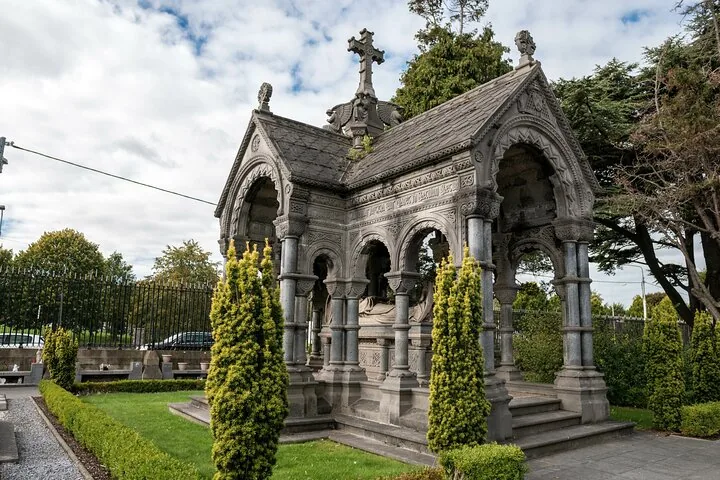 Ornate stone mausoleum surrounded by trees in Glasnevin Cemetery
